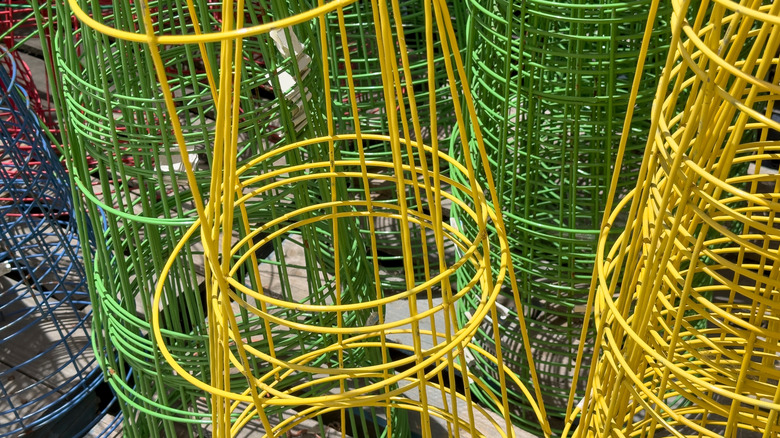 Stacks of upside-down tomato cages in yellow, green, blue and red are shown