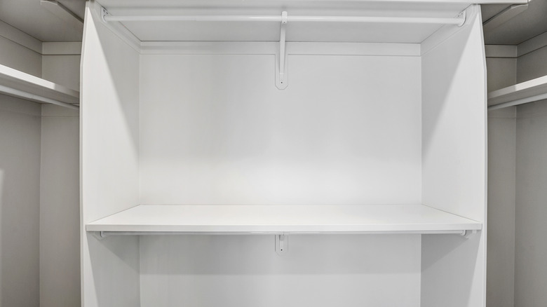 Empty white shelf inside of a closet
