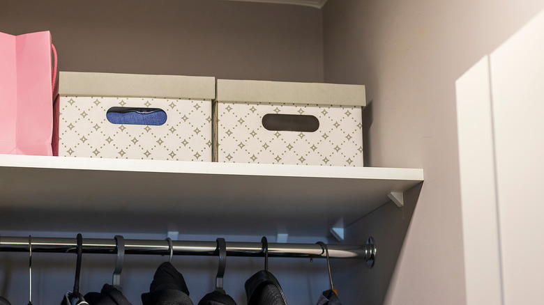 Storage bins with lids on a closet shelf