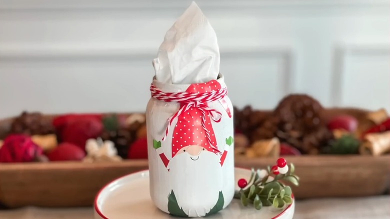 A gnome-themed painted tissue jar with napkins inside