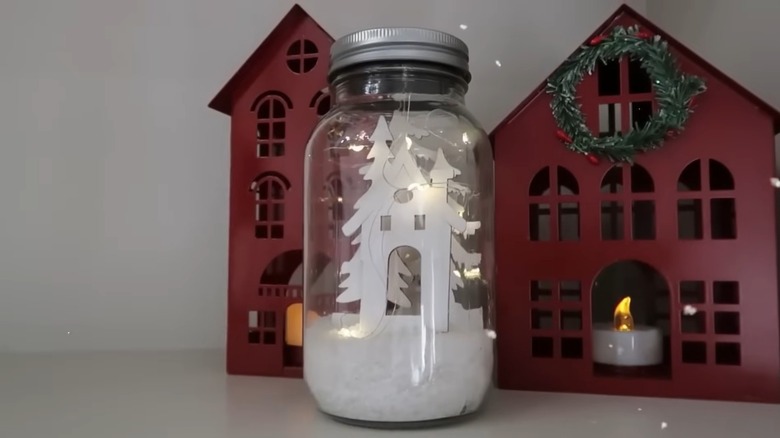 A white house and tree structure inside a glass jar