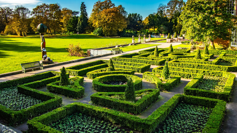 Formal garden on a sunny day with beds, lawns, and neat hedges