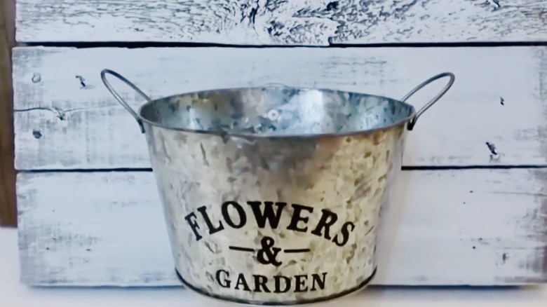 DIY wall decor made from a wood palette and galvanized bucket