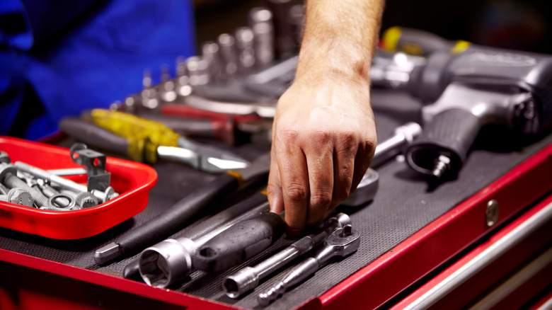 Person sorting tools in a toolbox