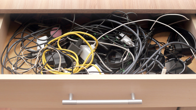 Junk drawer filled with tangled charger cords