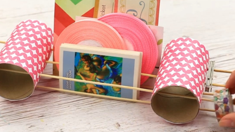 A decorative office supply holder made from paper towel rolls.