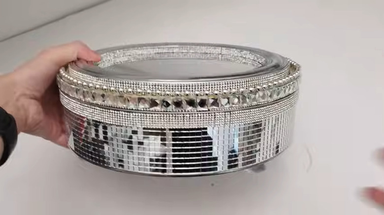 A bedazzled cookie tin for storing makeup and jewelry.