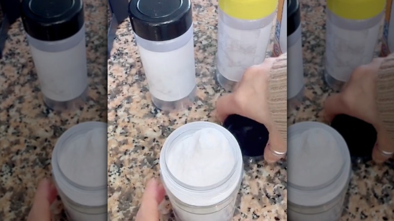An old plastic spice jar reused to store baking soda.