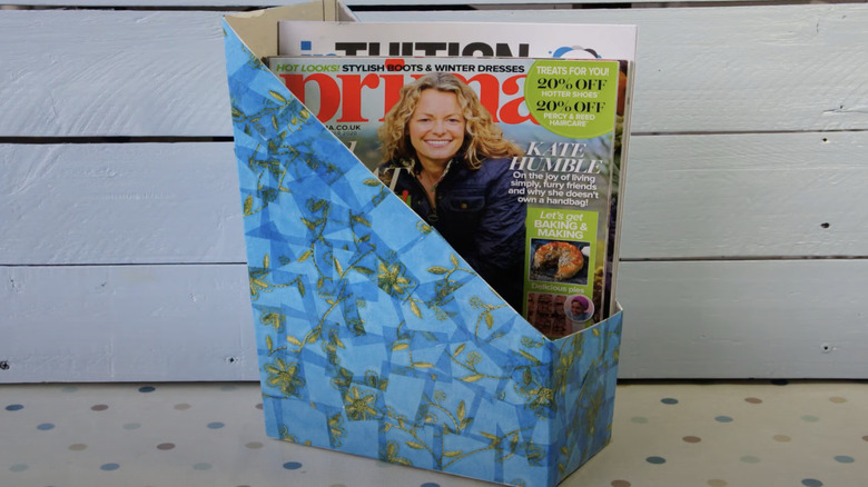 A magazine holder made from a cereal box.