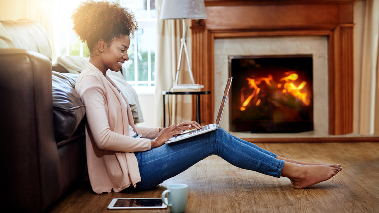 Woman sitting by fireplace