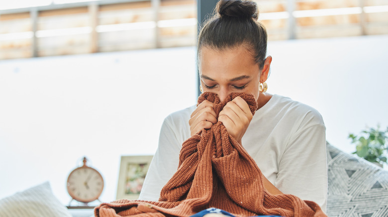 Woman smelling a freshly laundered sweater