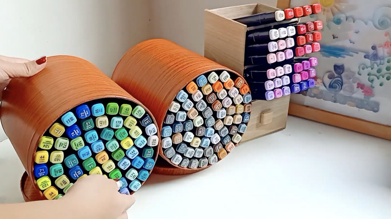 Repurposed paint cans holding craft markers.