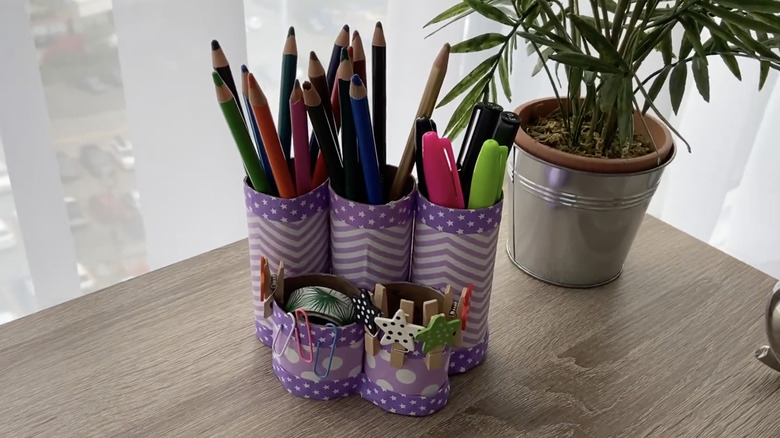 A stationery holder made from toilet paper rolls.
