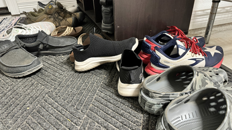 The bottom of a closet filled with messy shoes