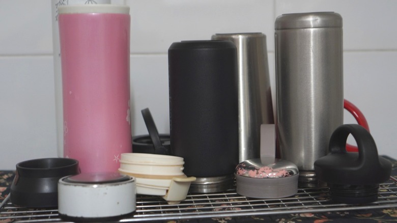 Mess of traveling mugs on a shelf