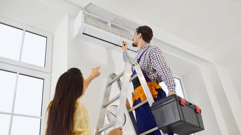 man and woman fixing aircon