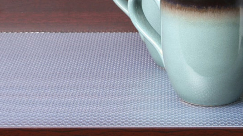 Con-Tact's shelf liners laid down on a shelf with two green coffee mugs on them