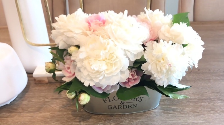 White and pink flowers on display inside a tin