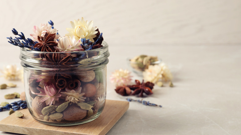 Potpourri in a small jar on a wood coaster