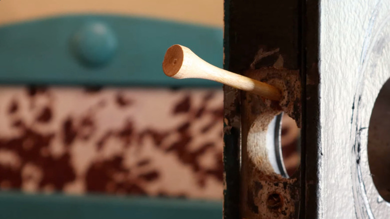 Golf tee in a door handle screw hole
