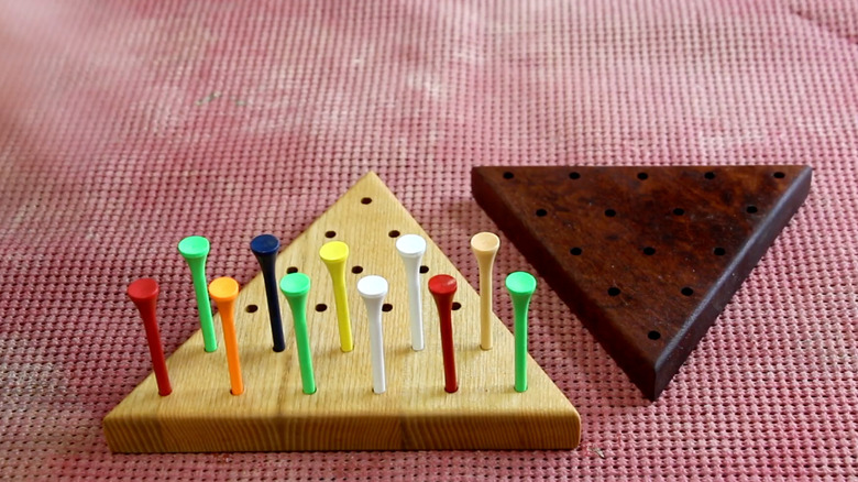 DIY peg solitaire game with colorful golf tees