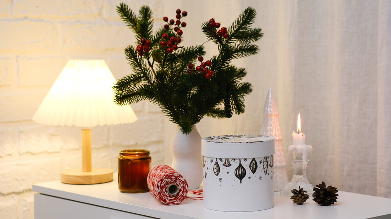 Pine trimmings in a vase next to other holiday decor
