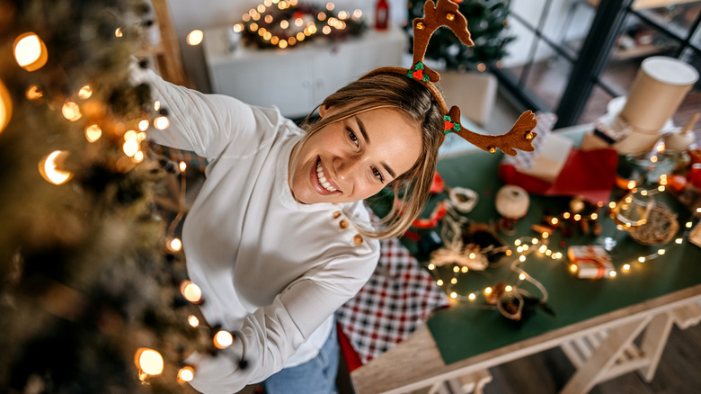 A person hanging holiday decor in a small room