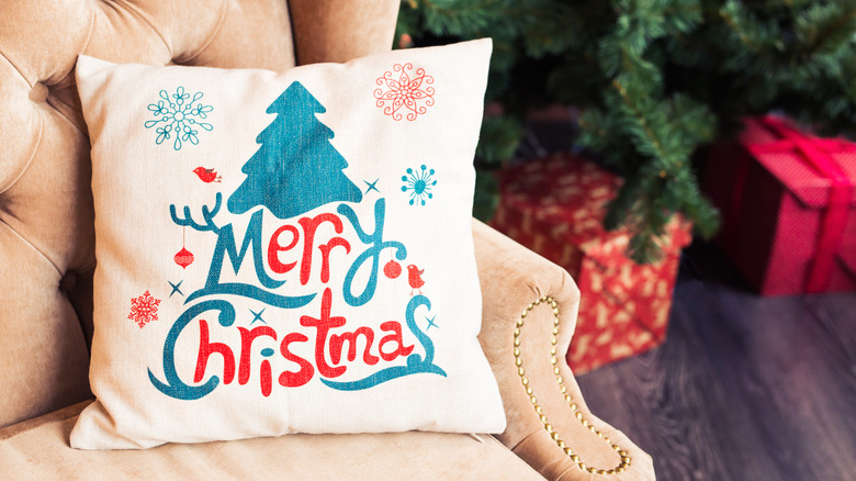 Christmas pillow on an armchair near a tree