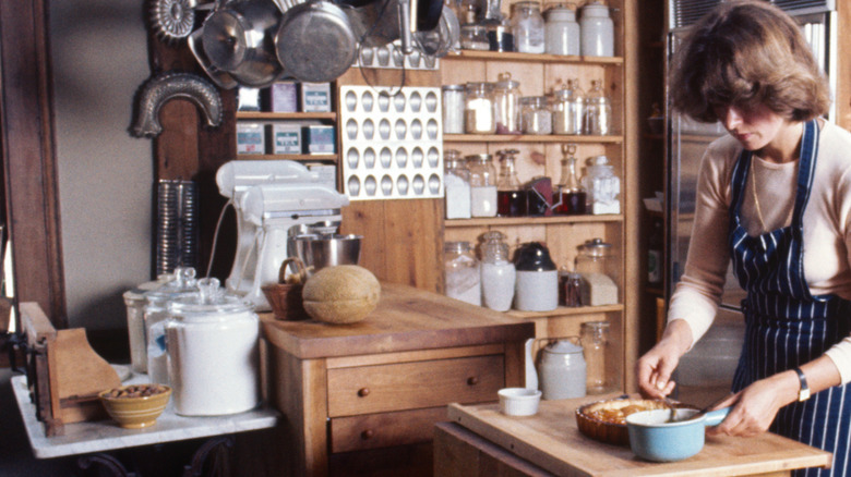 Martha Stewart baking in kitchen with cooking supplies on countertop and shelves