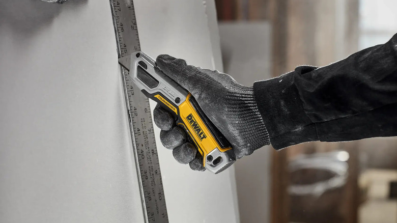 A person using DeWalt's Toughseries Retractable Utility Knife