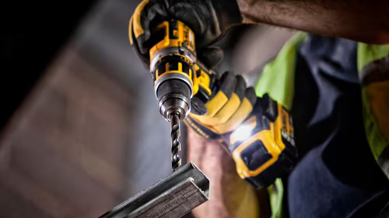 Bottom-up view of a person drilling with a bit from DeWalt's Black and Gold Twist Drill Bit Set