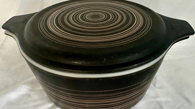 A Pyrex Terra bowl and lid in black with gold rings