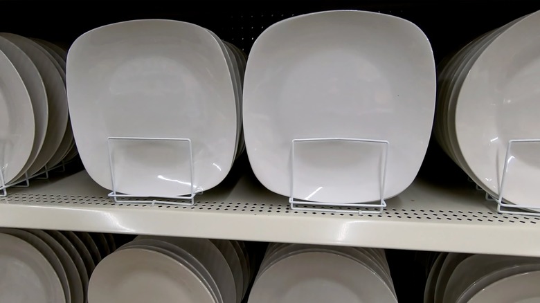 Screenshot of YouTube video, showing rows of square and round plates displayed upright on shelves.