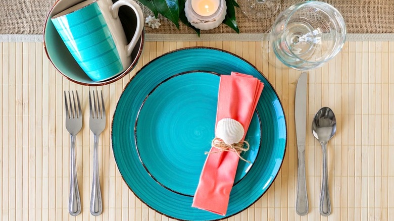 A place setting with Dollar Tree's Turquoise Swirl Stoneware plates and the matching mug inside the bowl.
