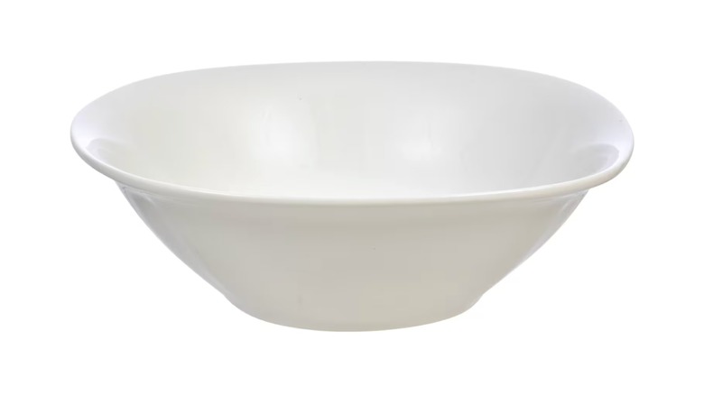 A white Dollar Tree bowl with a misshapen rim displayed against a white background.