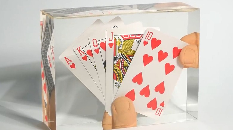 Royal flush hand of cards embedded in a block of clear resin
