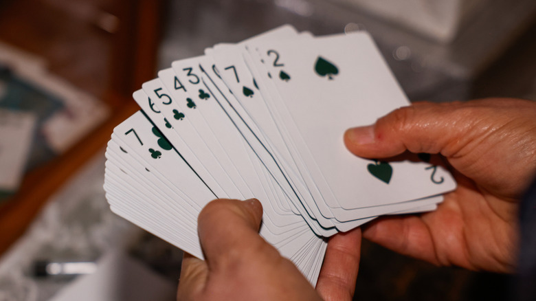 A pair of hands holding playing cards