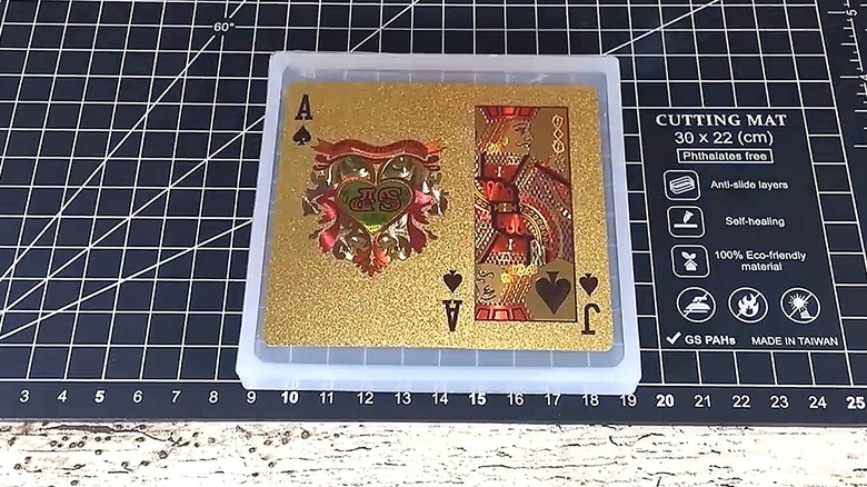 Gold playing cards embedded in resin in a mold to make coasters