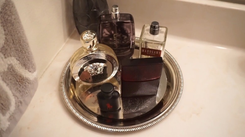 Perfume bottles placed on a golden plated in a bathroom