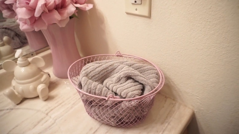 Towels in a pink plastic basket on a countertop