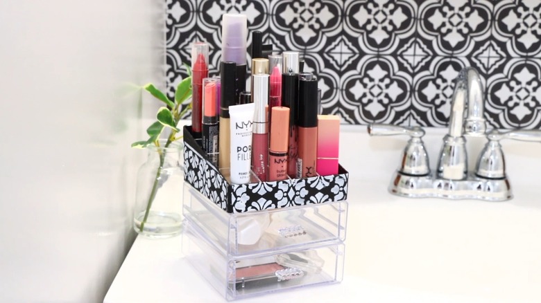 A stackable organizer holding makeup on bathroom countertop
