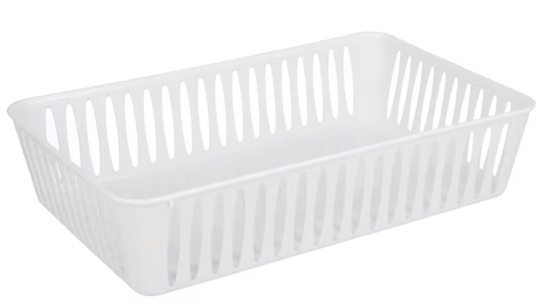 Close-up of a rectangular white slotted basket against a white background.