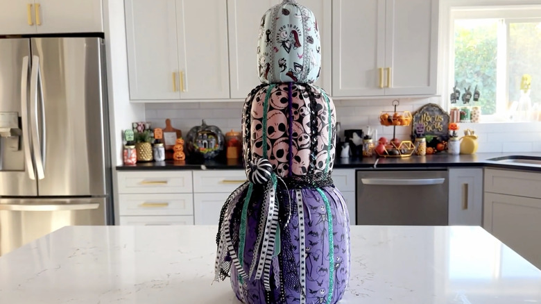 Stack of pumpkins covered in Nightmare Before Christmas fabric and accented with ribbons