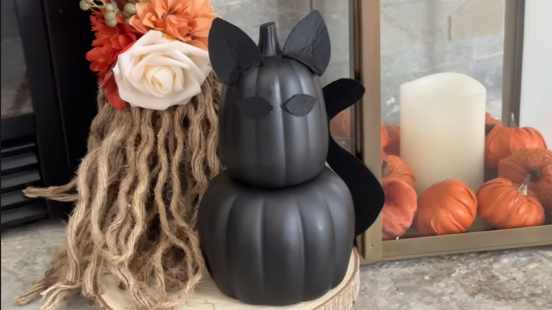Black cat decoration made from two stacked plastic pumpkins and black felt