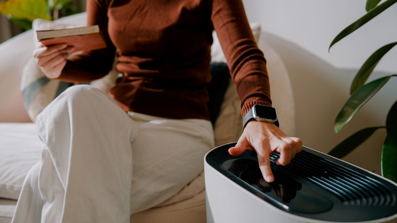 Woman adjusting the temperature on a portable air conditioner