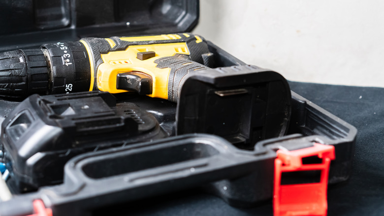 Yellow and black drill and battery in storage case