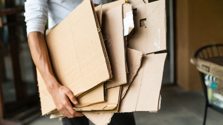 Man holding folded pieces of cardboard
