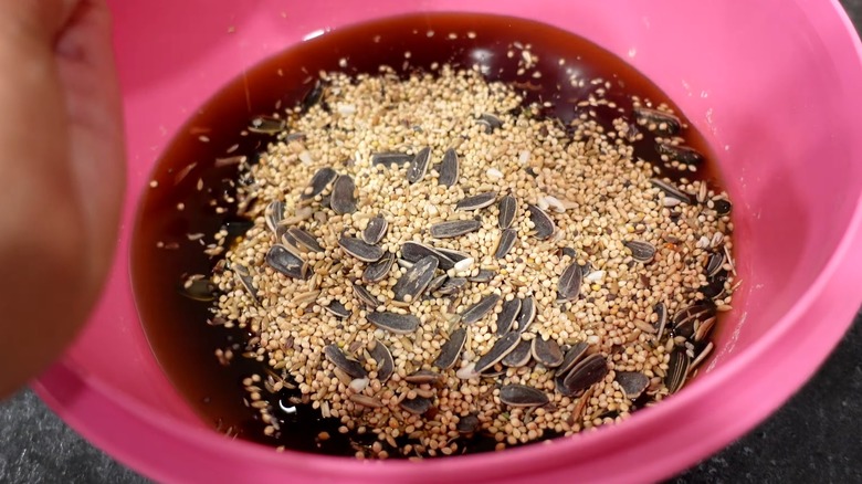 Millets and seeds being mixed in beef tallow