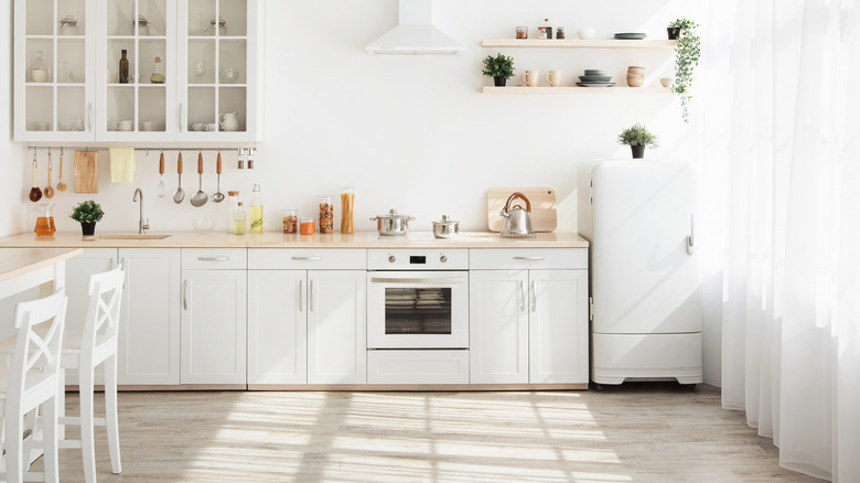 An all white kitchen with white kitchen appliances.