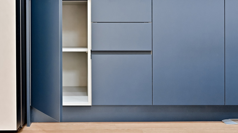 Toe kick under blue cabinet with wooden floor